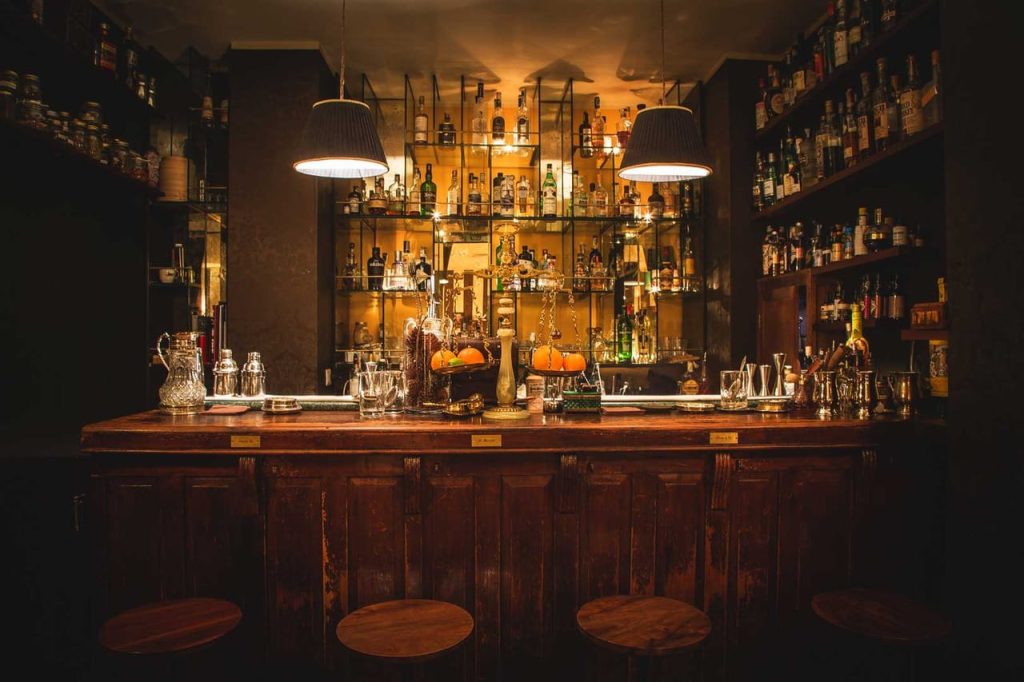 Counter and bottles on display in a speakeasy bar.