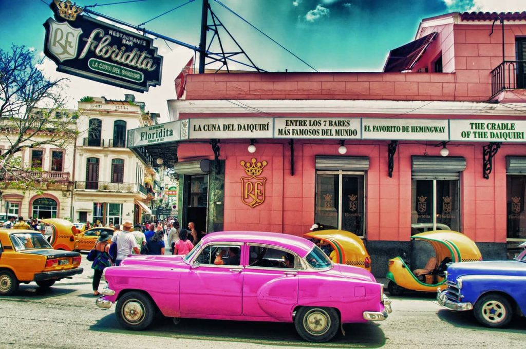 Bar Floridta in Cuba and a pink car next to it.
